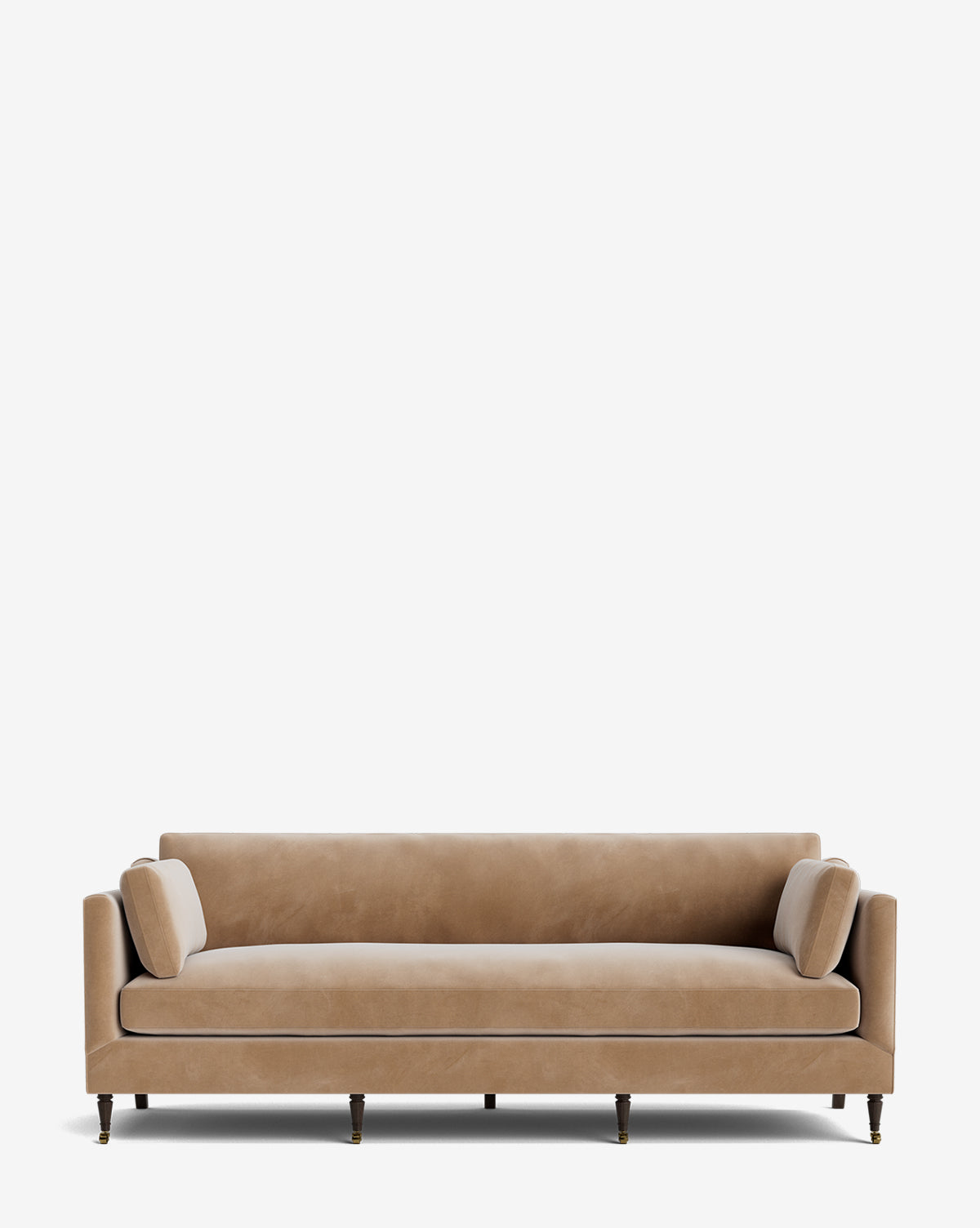 The Haverford Upholstered Sofa 90 is a modern, tan velvet sofa with straight arms, cylindrical bolster pillows, and dark wooden legs on brass casters, photographed against a plain white background by McGee & Co.