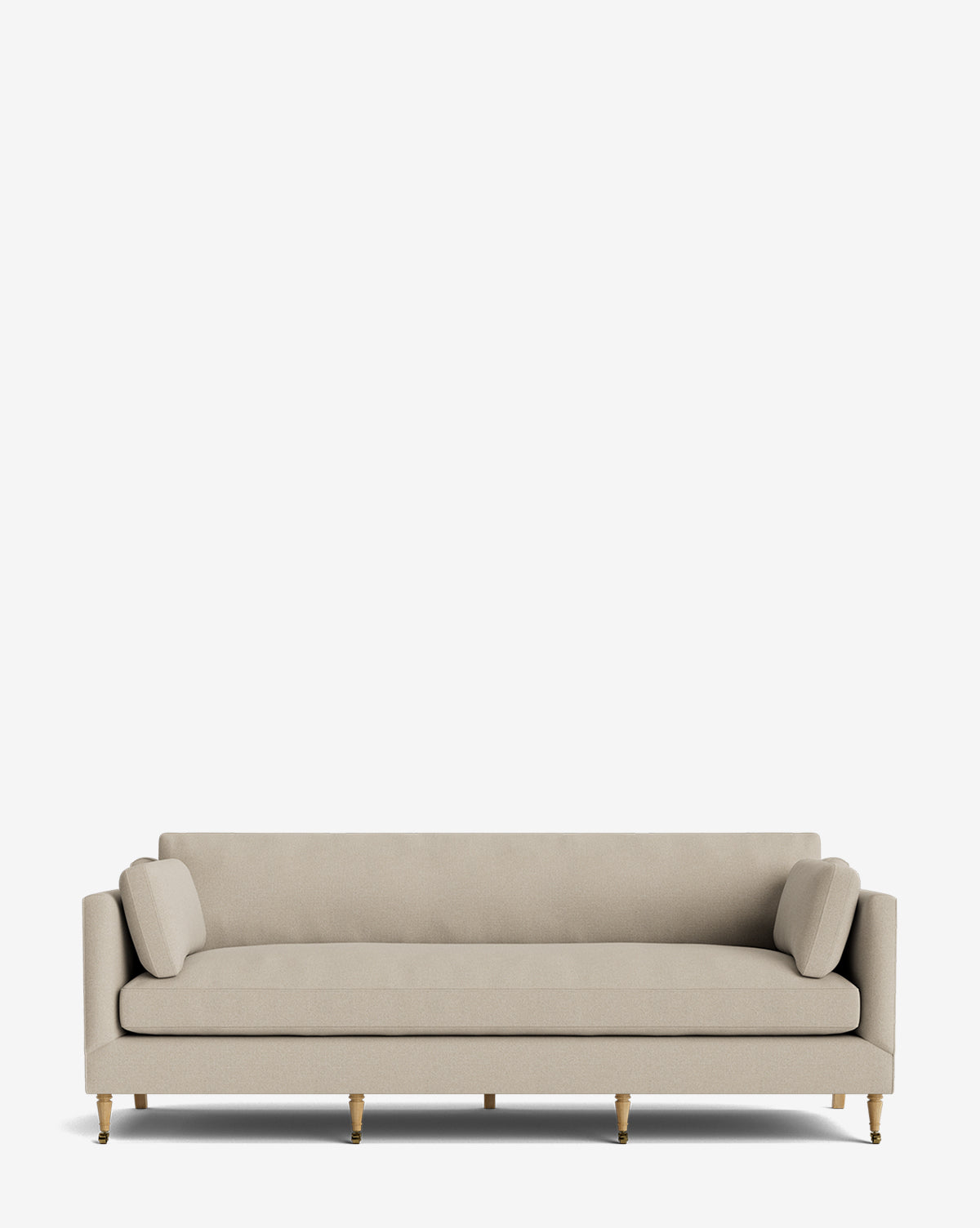 A modern beige Haverford Upholstered Sofa 90 featuring clean lines, gold-tipped wooden legs, and two matching cylindrical bolster pillows, shown against a plain white background by McGee & Co.