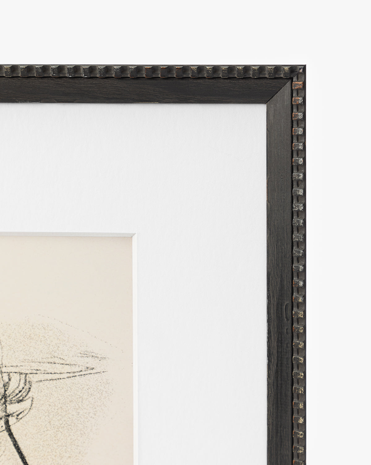 Close-up of the Head Study black picture frame with a textured, studded edge, showing the top right corner of a matted artwork featuring expressive linework from a sketched portrait on white by McGee & Co.