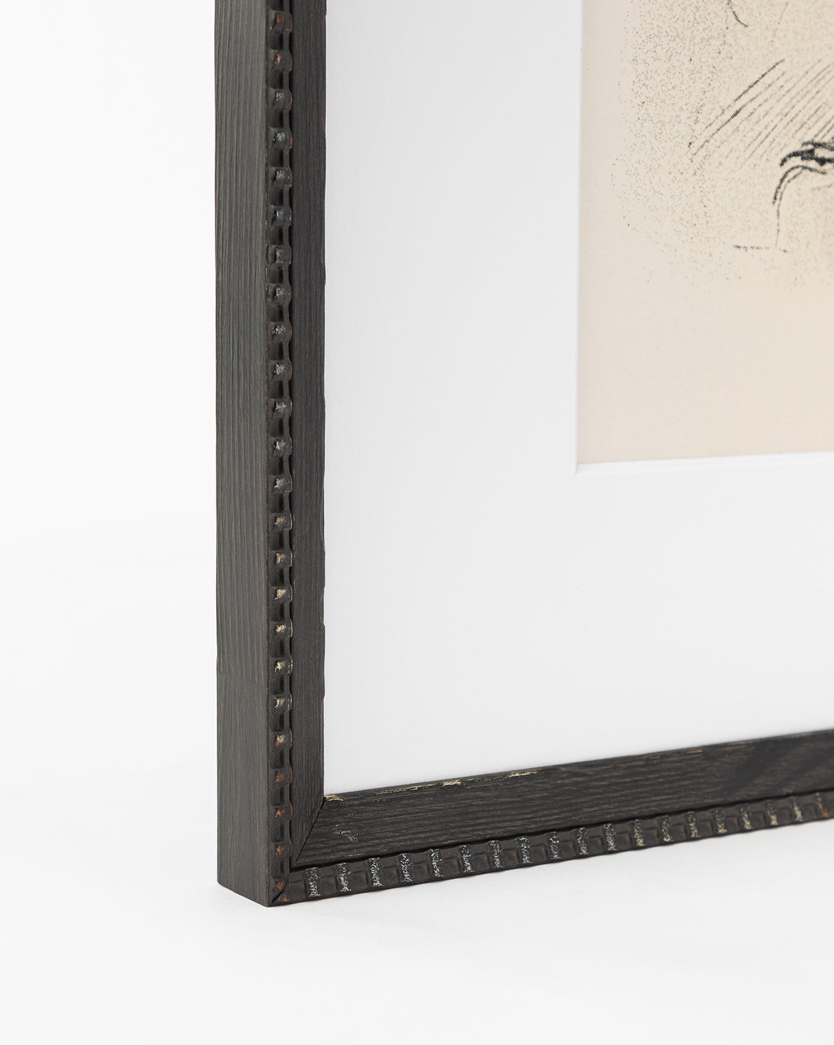 Close-up of the corner of a dark wooden frame with a beaded edge and white mat displaying Head Study. Perfect for showcasing sketched portraits or expressive linework. White background enhances the artworks detail, by McGee & Co.