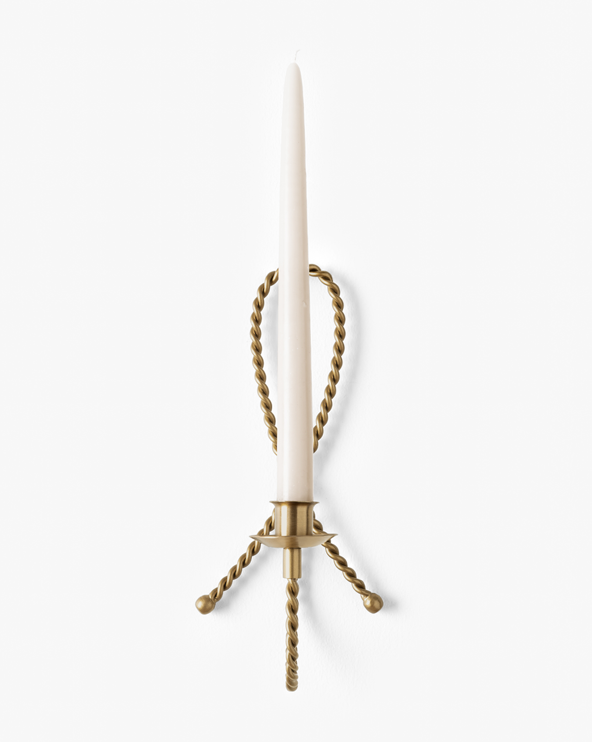 The Hearst Taper Holder is a sculptural brass wall sconce with twisted metal arms that holds a tall, slender white candle upright against a plain white background, by McGee & Co.