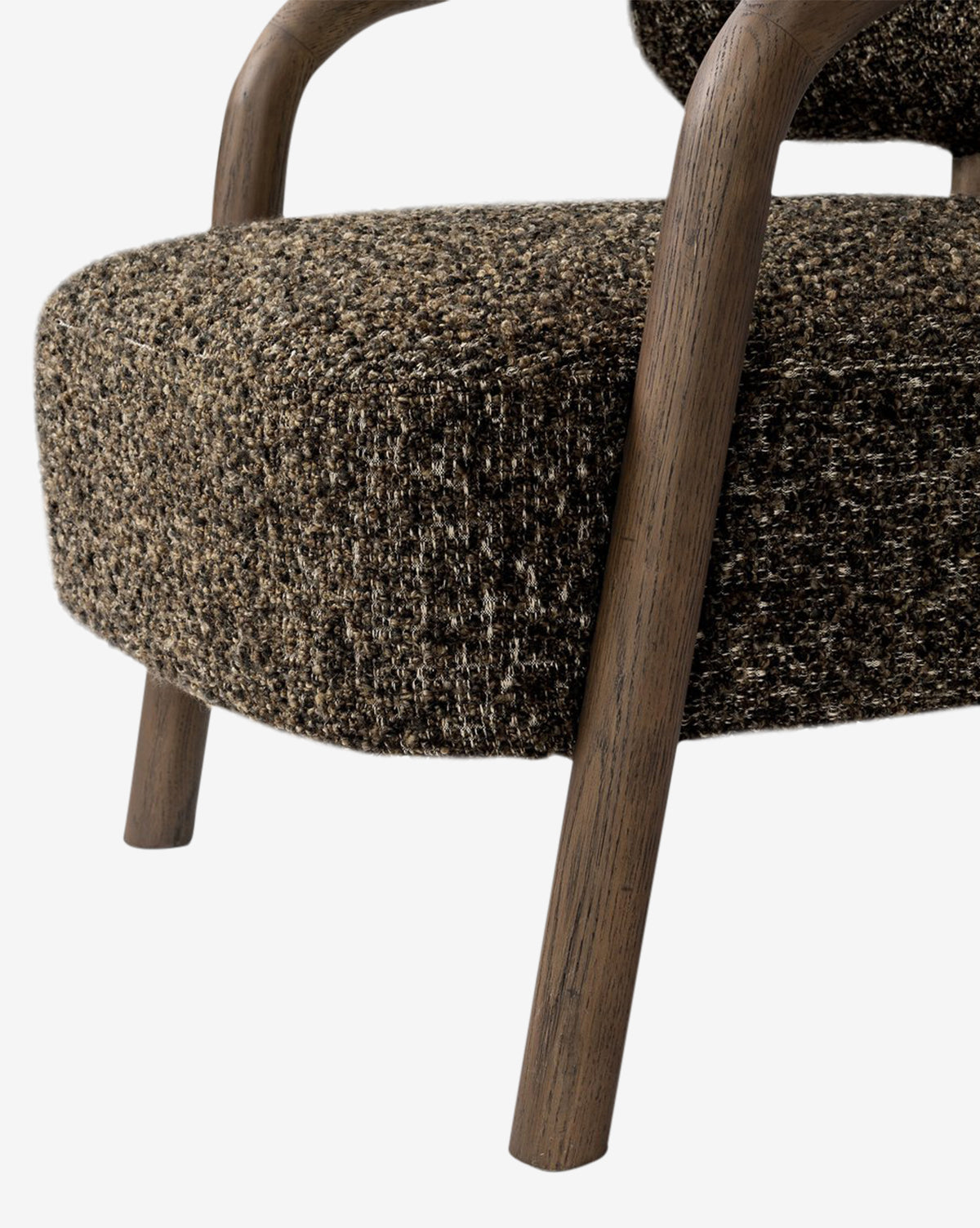 Close-up of the Holstein Lounge Chair, showcasing textured brown faux Mongolian shearling upholstery and a solid oak frame with wooden legs and armrests, set against a white background by McGee & Co.