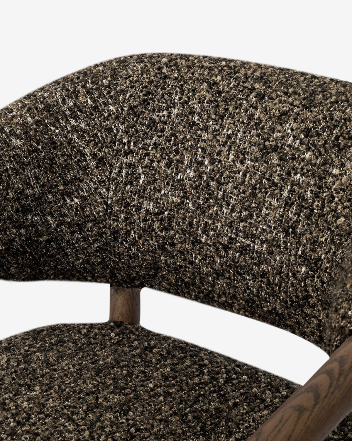Close-up of the Holstein Lounge Chair, showing its curved backrest and seat in textured, speckled brown fabric, with solid oak frame accents visible at the base of the backrest, by McGee & Co.