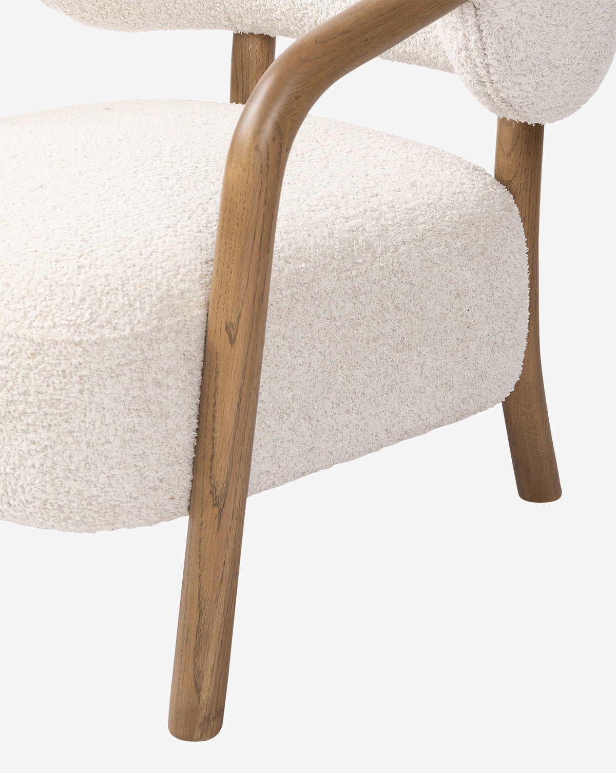 Close-up of the Holstein Lounge Chair featuring a curved solid oak frame and armrest, upholstered in textured faux Mongolian shearling. The design emphasizes the contrast between smooth wood and soft fabric, by McGee & Co.