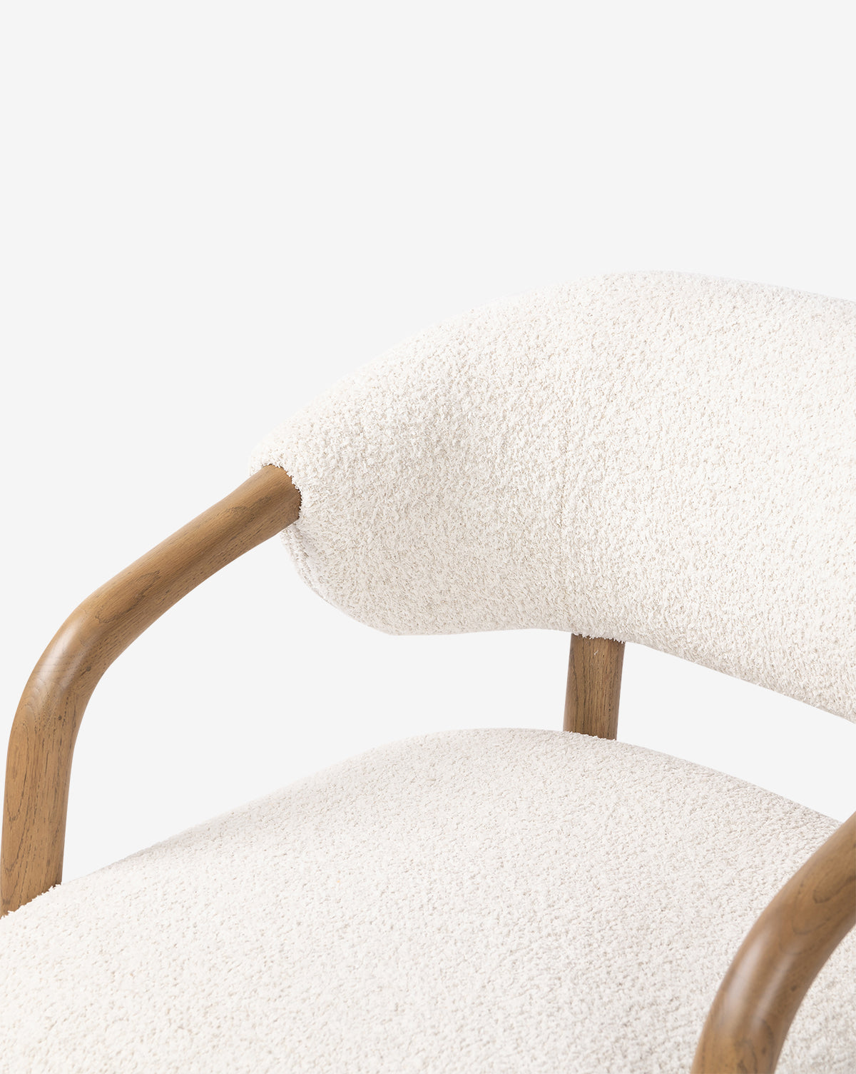 Close-up of the Holstein Lounge Chair, showcasing light wood curved armrests and soft faux Mongolian shearling upholstery on the seat and backrest, set against a plain white background, by McGee & Co.