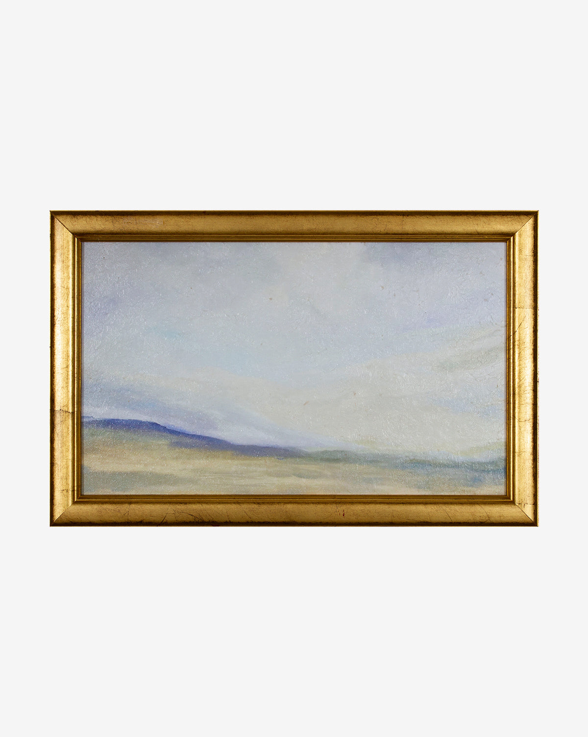 Indigo Skyline is a pastel landscape painting in soft blue, green, and beige hues, showing a misty horizon and low hills. It comes elegantly set in a gold wood frame against a plain white background.