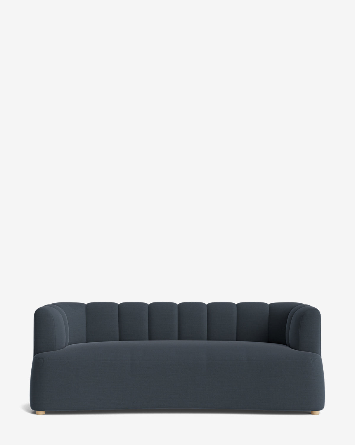 The Ines Sofa 90 is a modern dark blue velvet sofa with a low back and sides, vertical channel tufting, and short wooden legs, shown against a plain white background by McGee & Co.