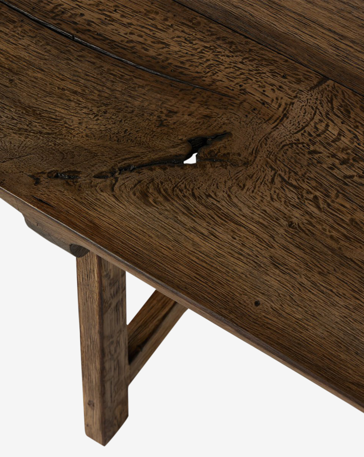 Close-up of the Inka Bench’s rustic wooden top, featuring a natural crack and textured grain, highlights its artisanal craftsmanship and sturdy legs in rich brown tones against a white background, by McGee & Co.