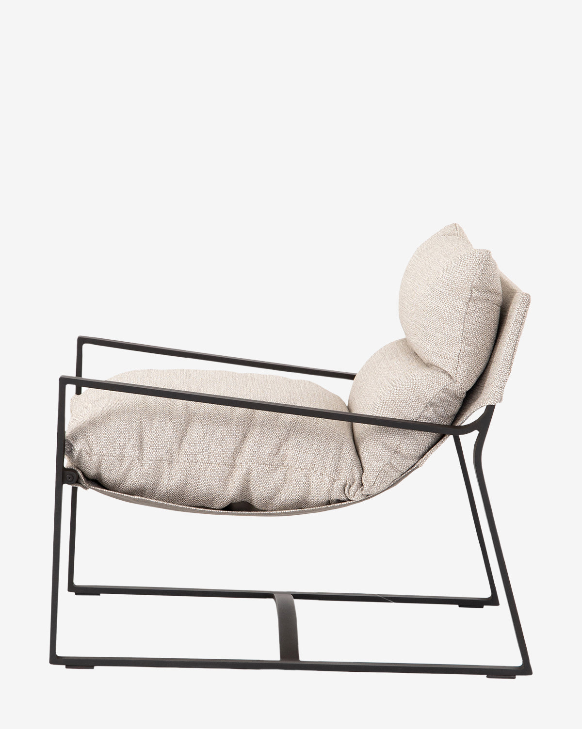 The Ismay Sling Chair features a modern black metal frame with thick, light beige removable cushions on the seat and backrest, shown from the side against a plain white background by McGee & Co.