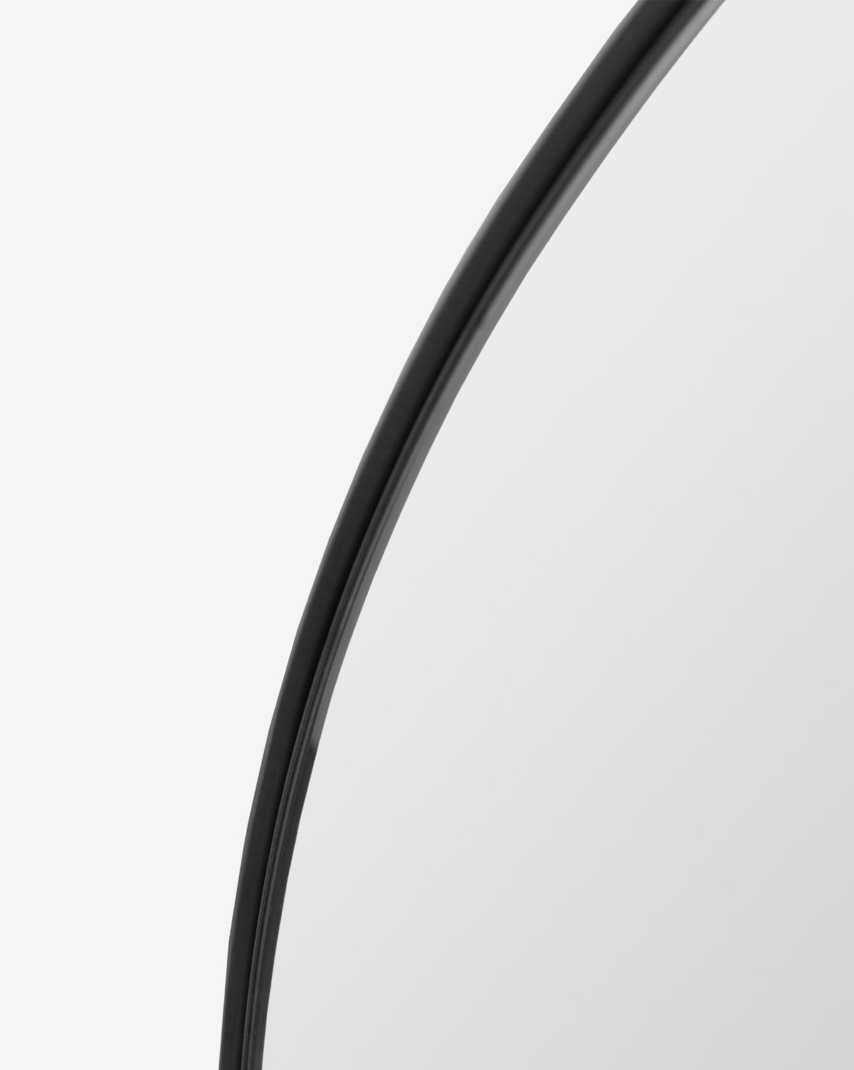 Close-up of the top right corner of the Jace Inset Circle Mirror, a round, shatterproof design with a thin black frame, shown against a plain white background, by McGee & Co.