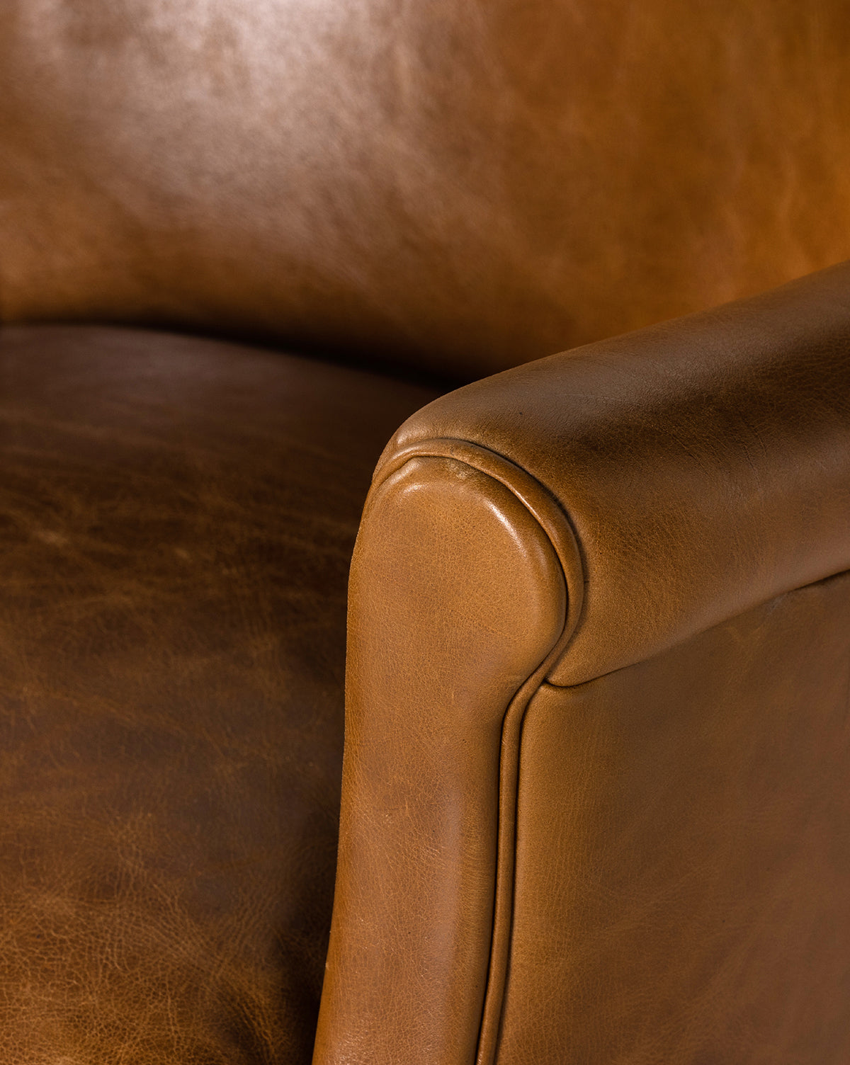 Close-up of the Jarah Lounge Chair highlighting its top-grain leather upholstery, smooth texture, and detailed stitching on the armrest and seat, by McGee & Co.