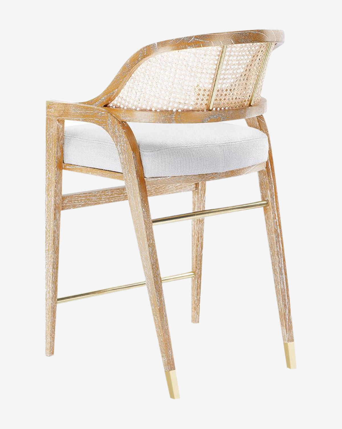 The Jensen Counter Stool has a solid Cape Lilac Mahogany frame, hand-woven cane back, white cushioned seat, gold metal footrest, and gold-capped legs, shown on a plain white background by McGee & Co.