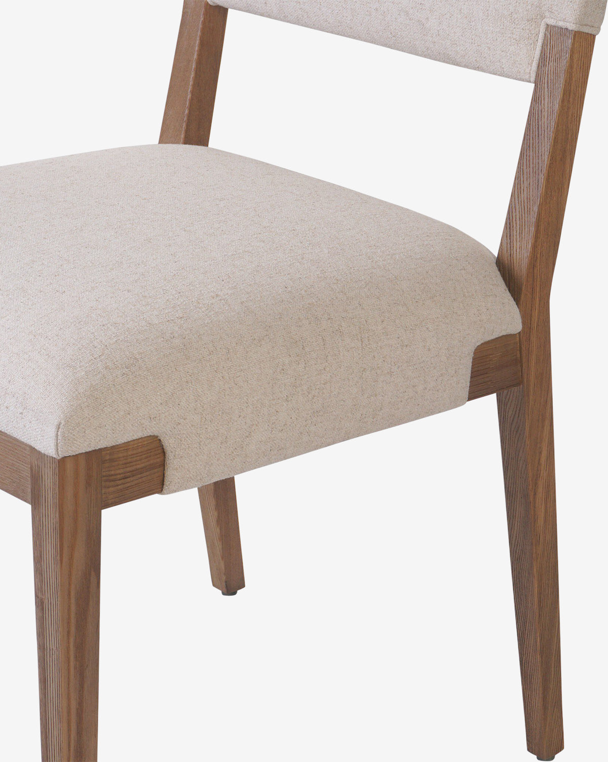 A close-up of the Kennebec Dining Chair, featuring an ash frame and light beige performance fabric on the seat and backrest, with clean lines and a minimalist design, by McGee & Co.