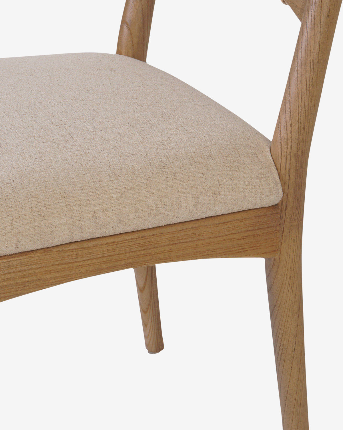Close-up of the Kimball Dining Chair, showcasing its wood frame, light beige upholstered seat, and gracefully curved legs and backrest against a clean white background, by McGee & Co.