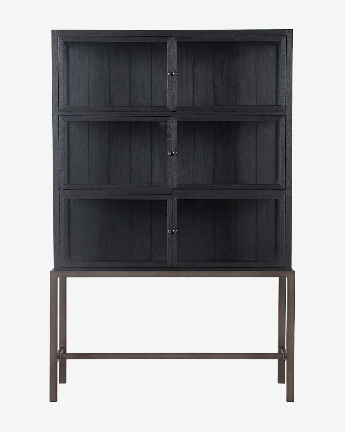The Lawley Cabinet is a tall, black drift oak curio with glass doors and six compartments. It stands on a sleek four-legged metal frame with a crossbar, set against a plain white background by McGee & Co.
