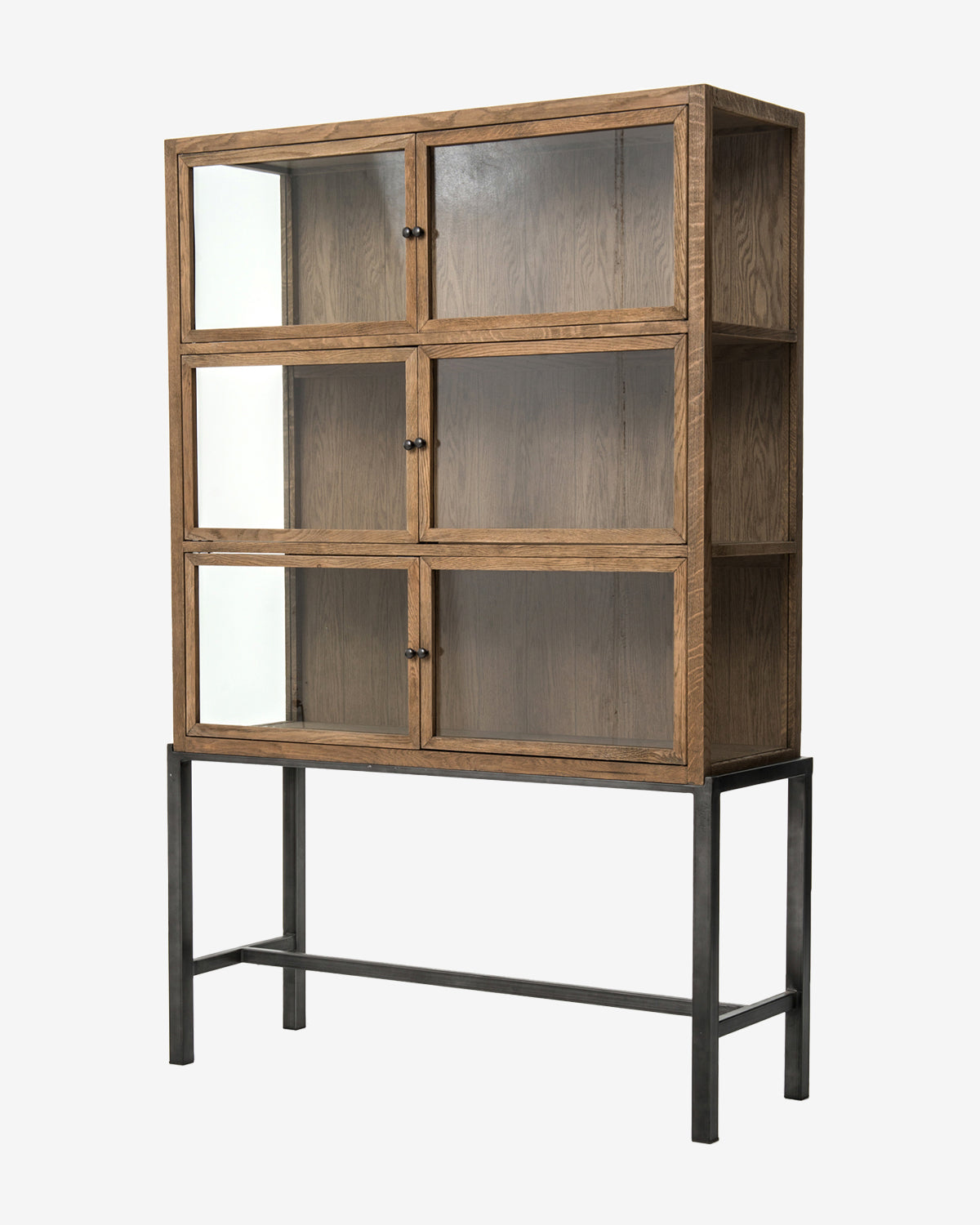 The Lawley Cabinet is a tall drift oak curio with six glass-front doors, black metal handles, and stands on a four-legged black metal frame, by McGee & Co.