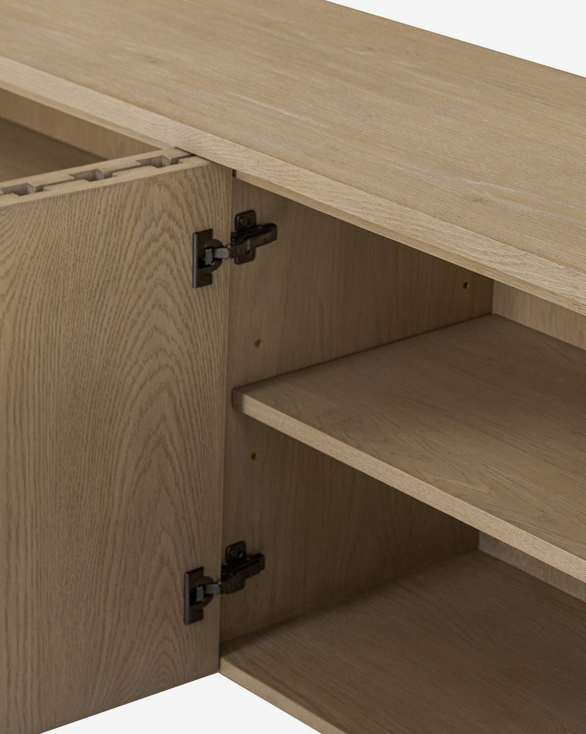 A close-up of the Leith Console in light oak shows its open door, two interior shelves, and metal hinges. The smooth design and contemporary style make this wooden piece a modern furniture highlight by McGee & Co.