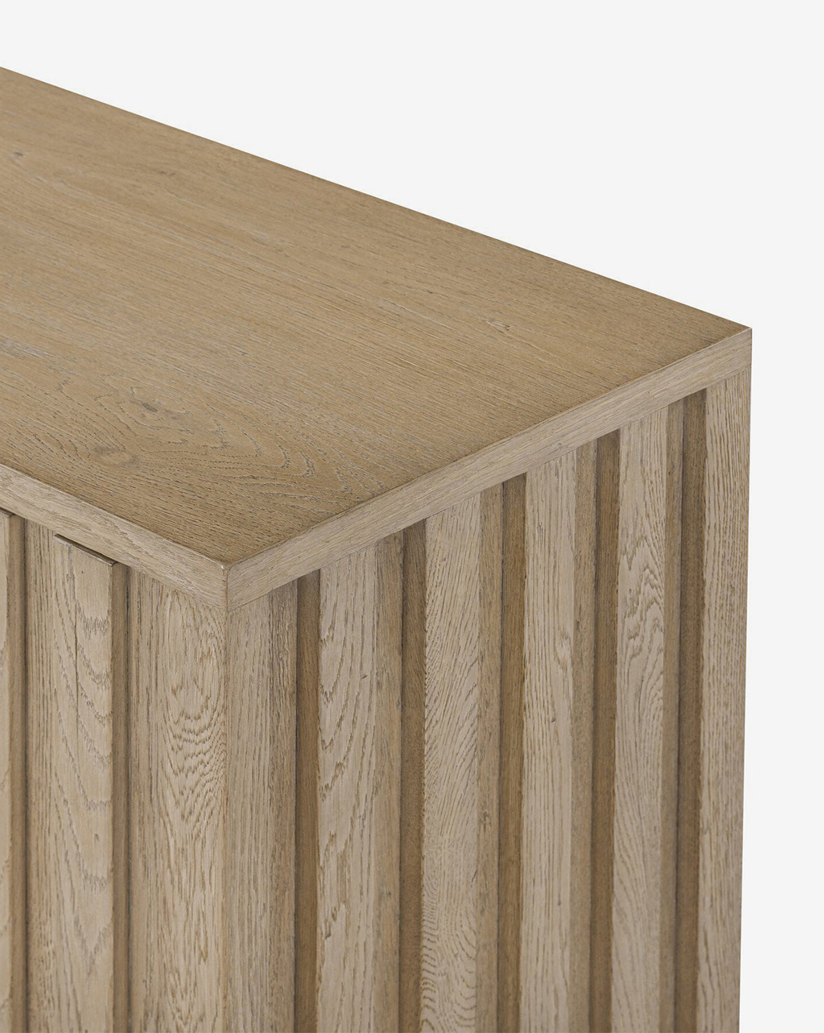 A close-up of the Leith Console shows its light wood finish and vertical grooved paneling. The surface’s natural wood grain texture enhances its modern, contemporary appeal, by McGee & Co.