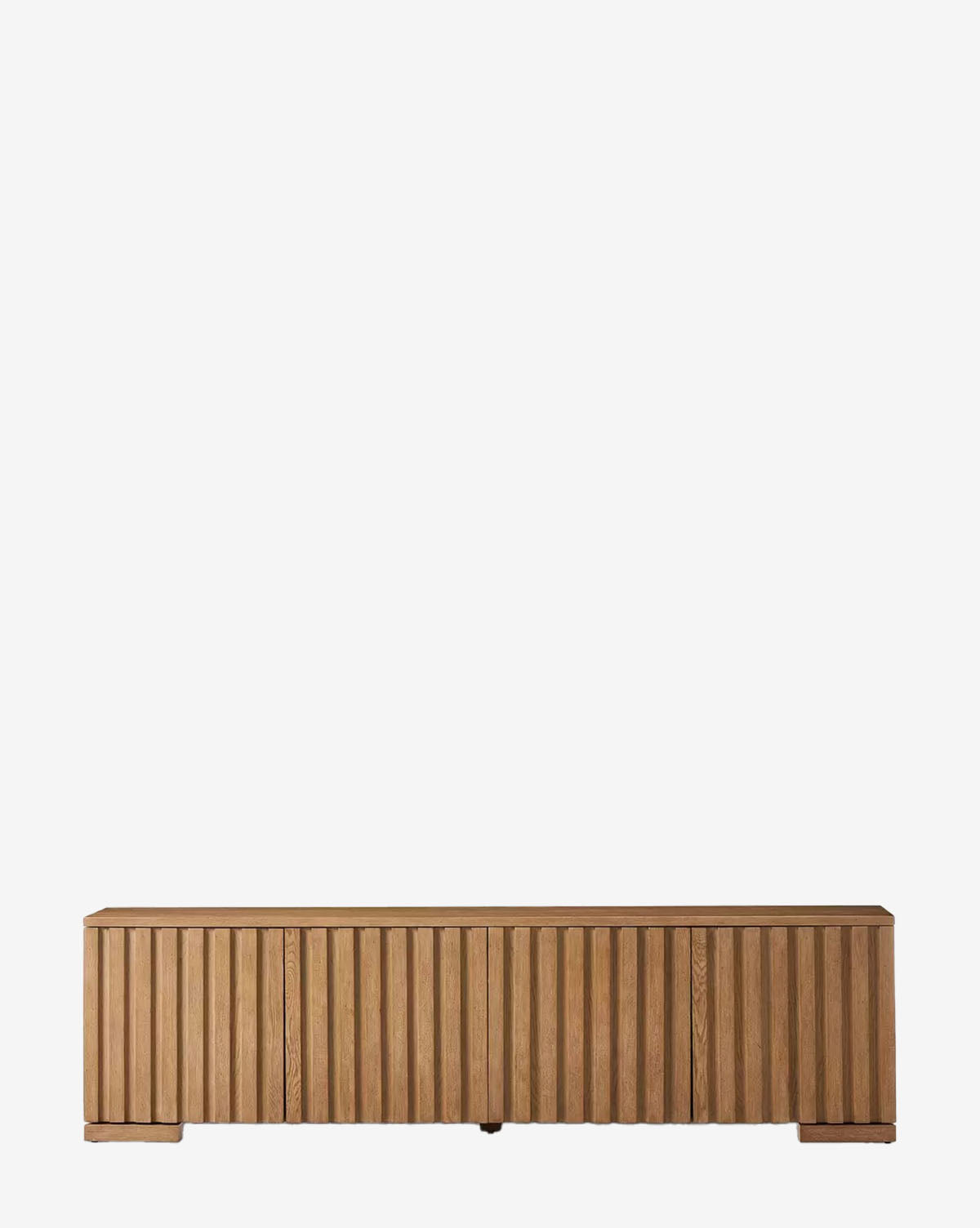 The Leith Console is a contemporary wooden storage cabinet with a light natural finish, vertical slatted front, and small block feet, shown against a plain white background by McGee & Co.