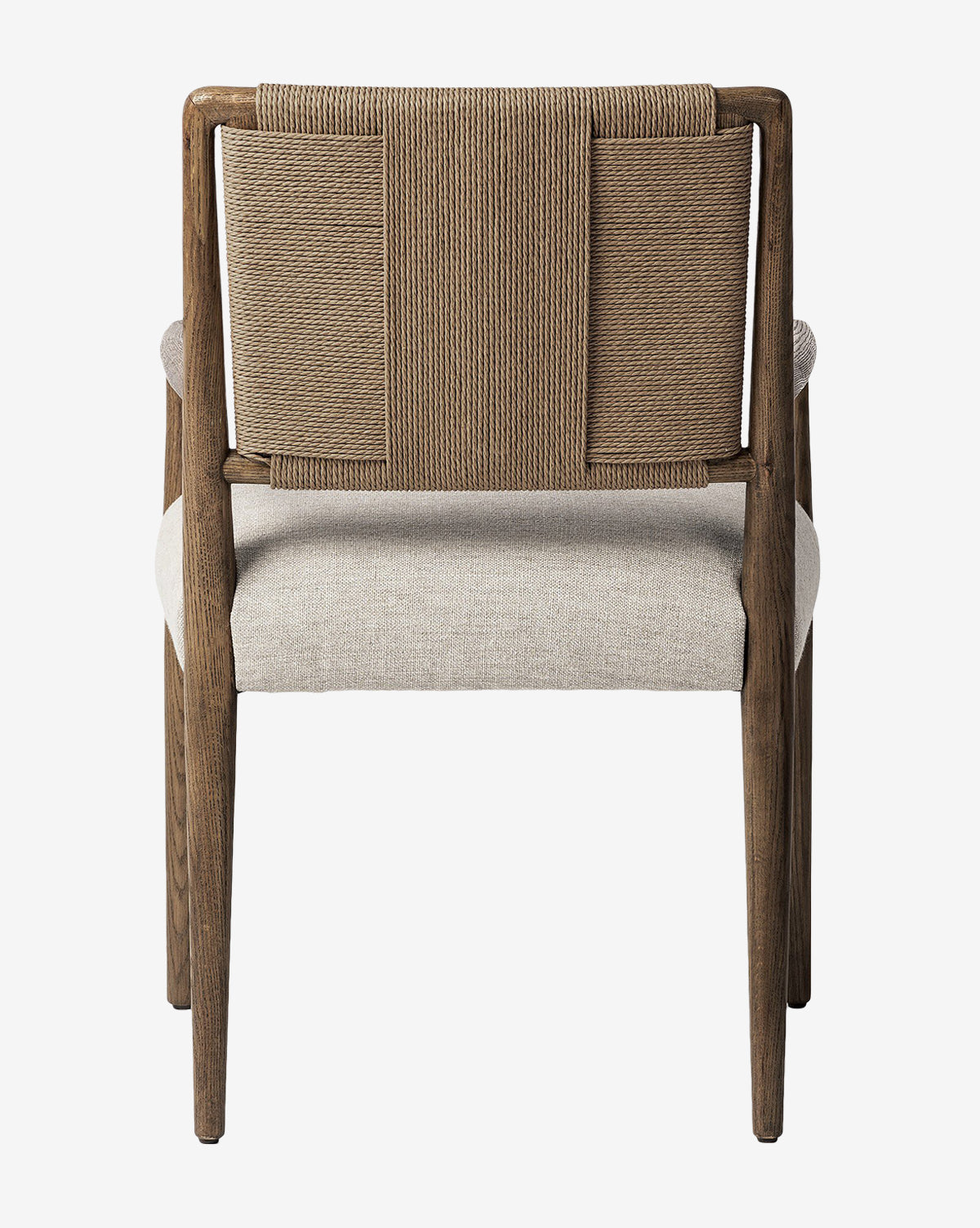 The Leola Dining Armchair is crafted from oak with a rush back and light-colored upholstered seat, seen from the back. Its design is modern and simple, featuring straight legs and clean lines by McGee & Co.