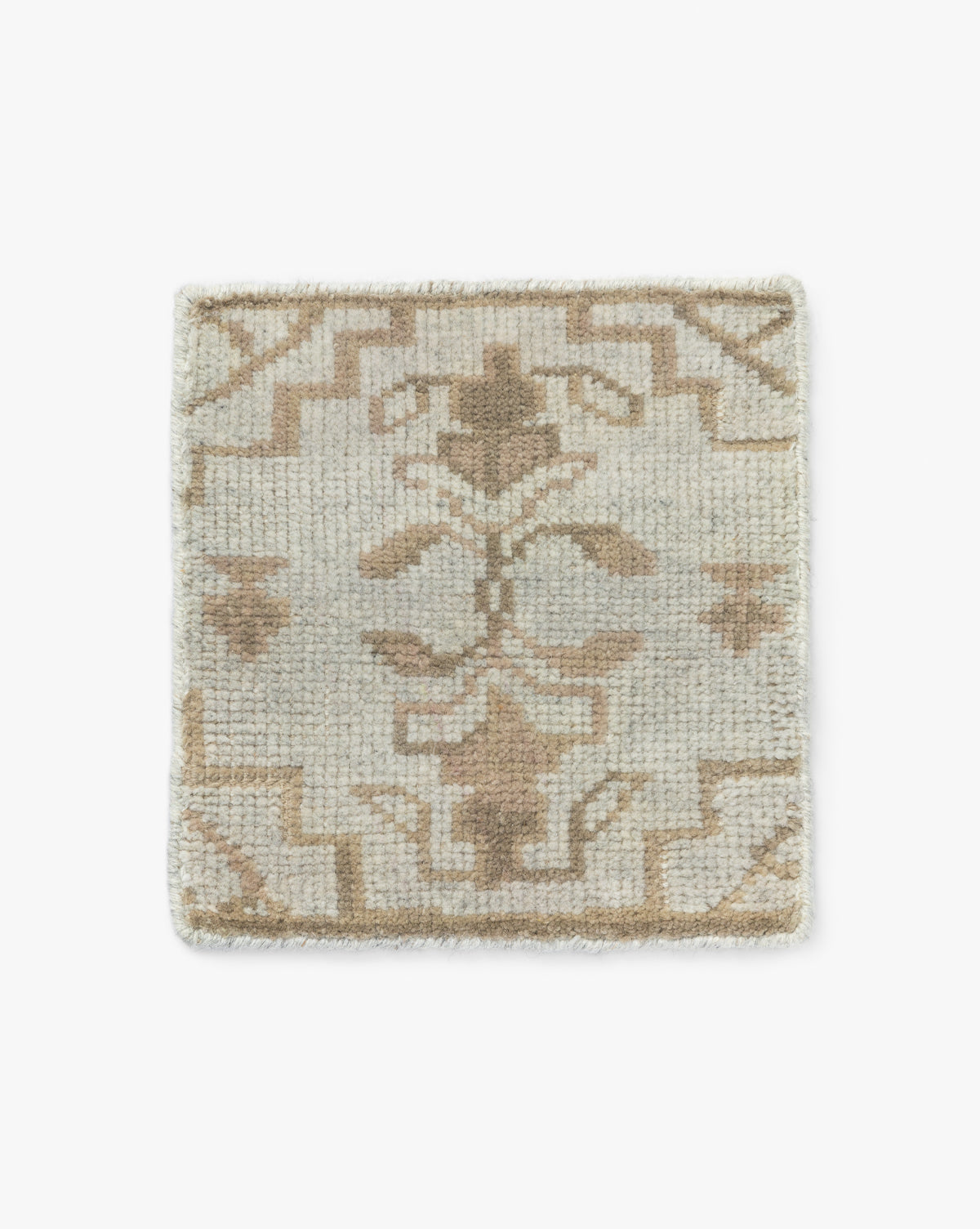 The Lexington Hand Knotted Rug Swatch is a square, beige and tan wool sample with a geometric and floral pattern, symmetrical designs, and a soft texture, displayed on a white background by McGee & Co.