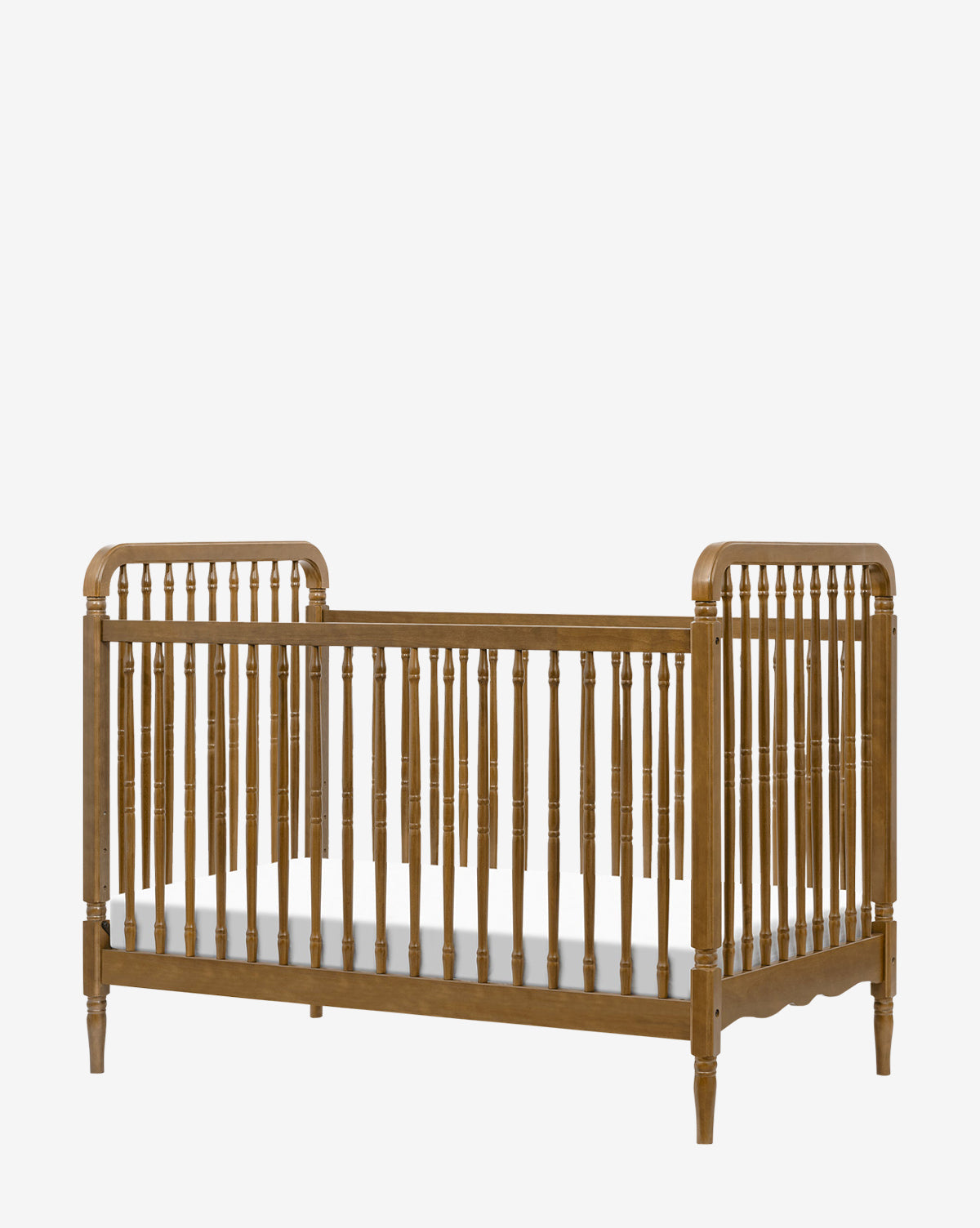 The Liberty 3-in-1 Convertible Spindle Crib with Toddler Bed Conversion Kit features vertical slats, turned spindles, rounded corners, and elegant legs, by McGee & Co. Its classic wooden design allows for easy toddler bed conversion against a plain white background.