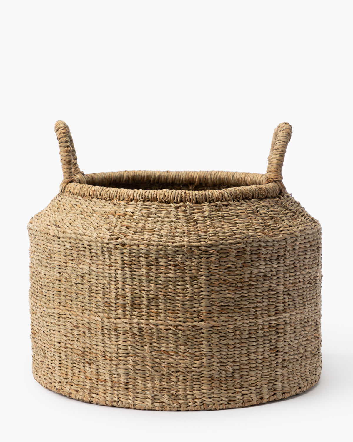 The Liesl Basket is a round basket made from woven mendong grass, featuring two upright handles, shown against a plain white background by McGee & Co.