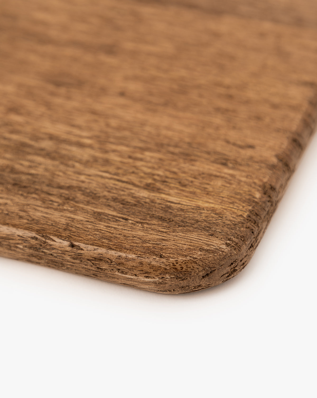 Close-up of the corner of the Longfellow Breadboard, highlighting its smooth, rounded edge and natural mango wood grain—an elegant accent for any kitchen decor, by McGee & Co.