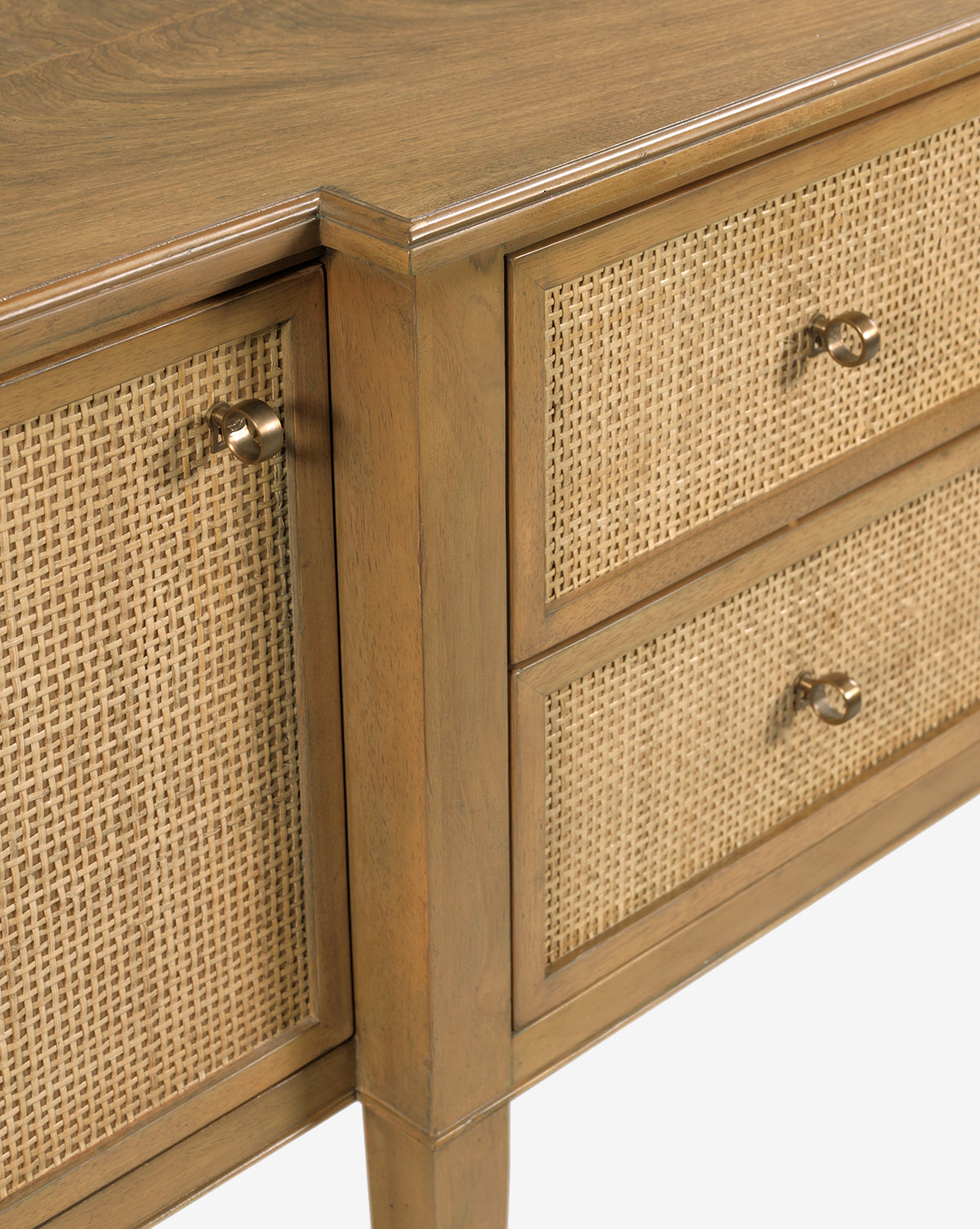 Close-up of the Lowie Buffet, a wooden dresser with natural cane doors and woven rattan drawer panels, each accented by a round metal knob, showcasing a rustic Italian-inspired design, by McGee & Co.