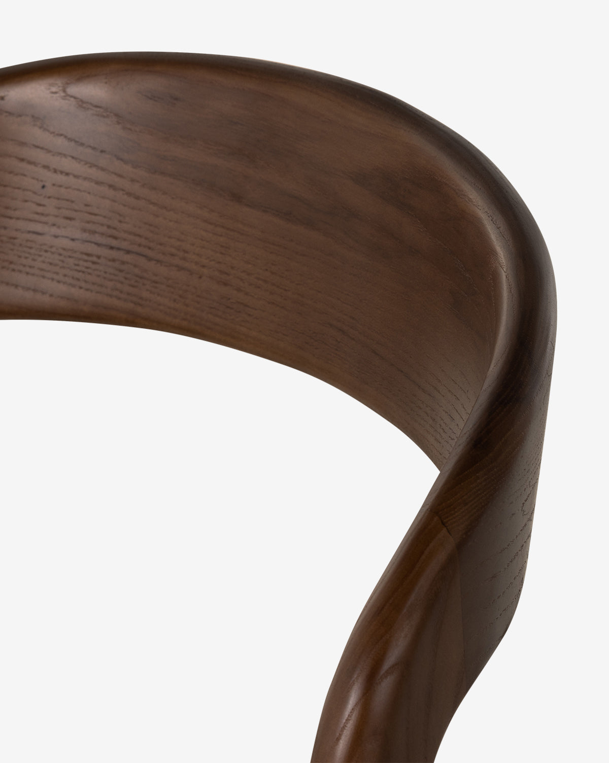 Close-up of the Lucinda Dining Chair’s curved, polished backrest showcases its smooth dark grain and Scandinavian design craftsmanship against a plain white background, by McGee & Co.