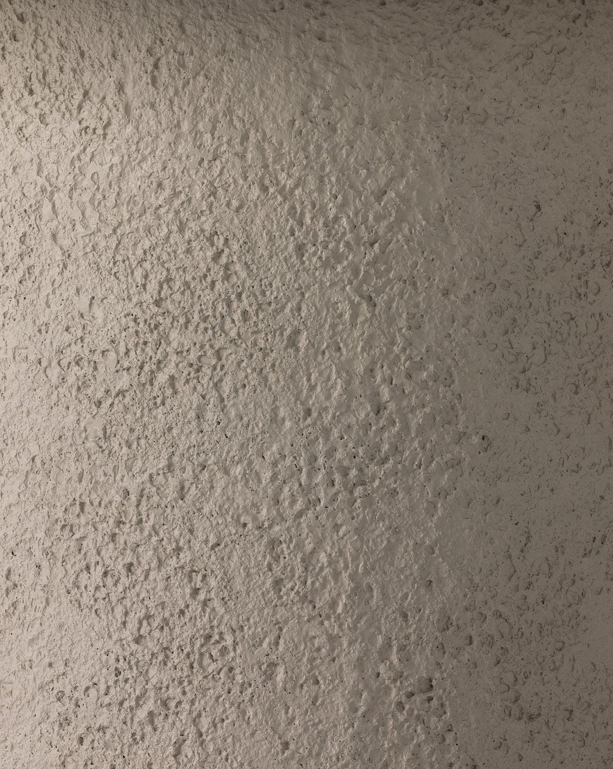 Close-up of a rough, textured beige surface with natural irregularities and uneven patterns—evoking the look of the Atalanta Outdoor Dining Table, by McGee & Co. Lighting highlights its contemporary concrete-inspired finish.