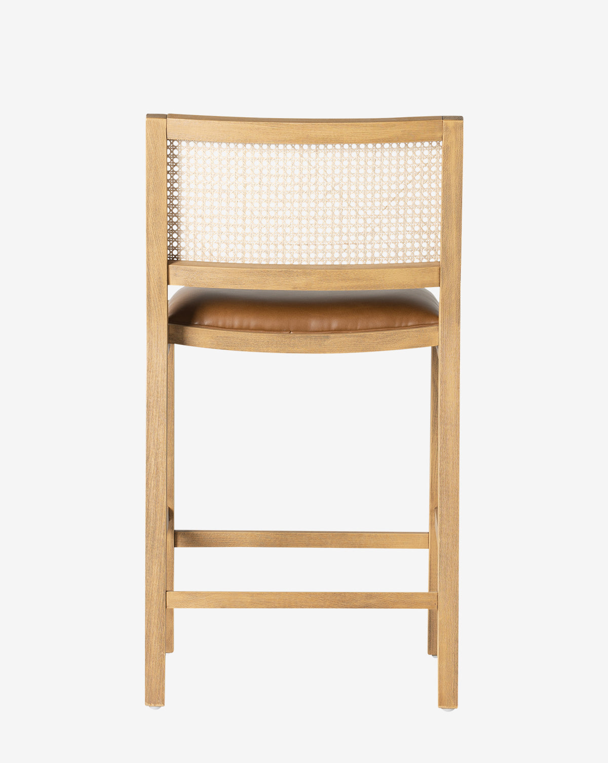 The Emeline Stool features a solid beech frame, woven cane backrest, and a light brown faux leather cushion, shown from behind against a plain white background by McGee & Co.