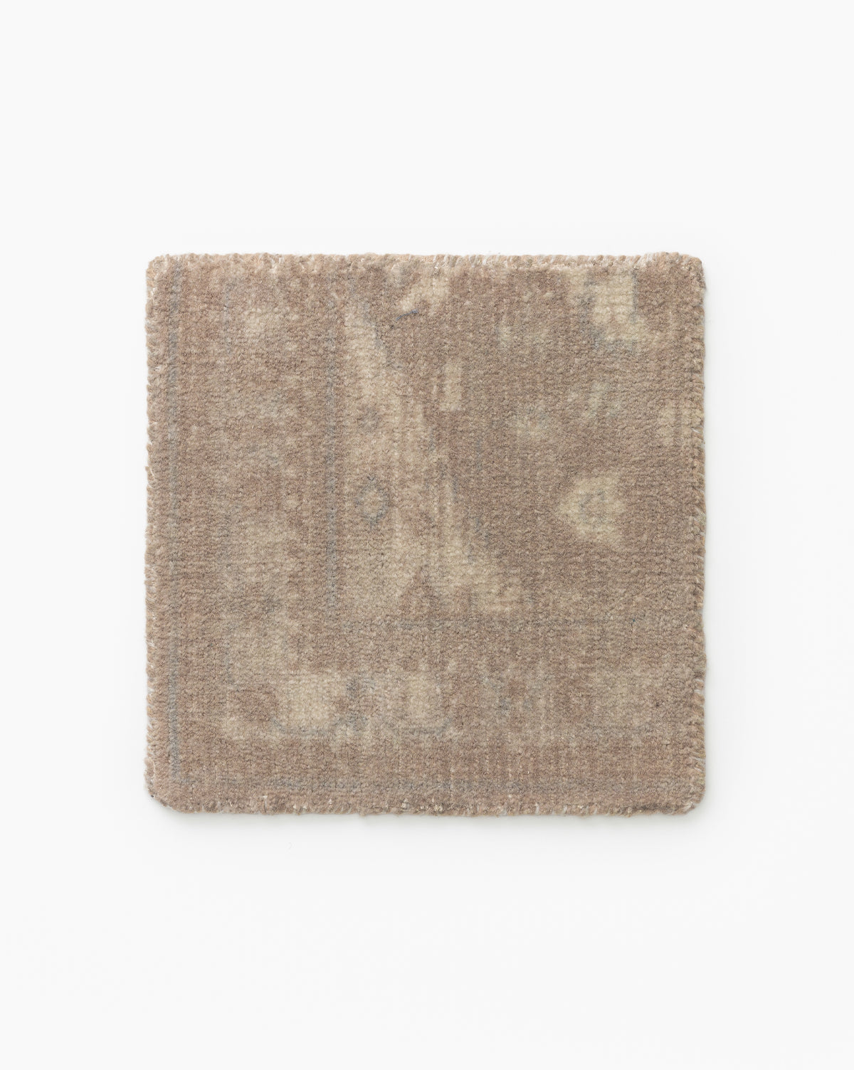 A square swatch of the Zaragoza Hand-Tufted Wool Rug in beige, featuring a subtle, faded pattern, shown against a white background by McGee & Co.