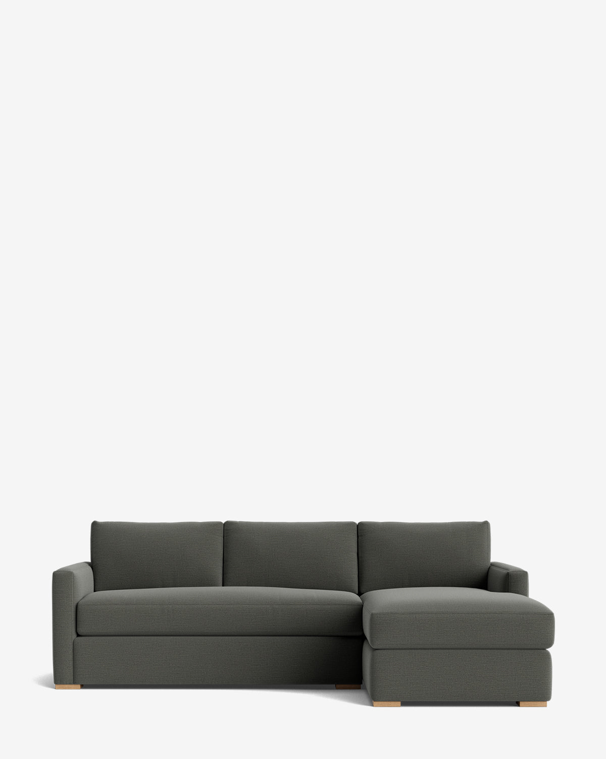 The Macy Upholstered Chaise Sectional 101 is a modern, dark gray living room piece featuring a right-side chaise lounge and light wooden feet, shown against a plain white background, by McGee & Co.