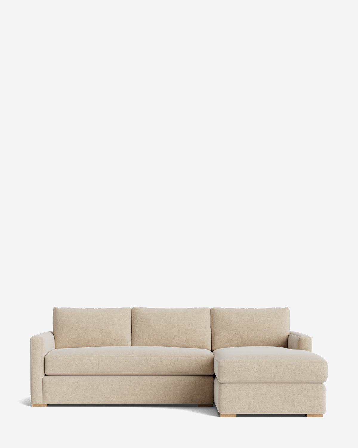 The Macy Upholstered Chaise Sectional 101 is a modern, light beige sofa with three seat cushions, a right-facing chaise, low wide arms, and wooden block feet, shown against a plain white background by McGee & Co.