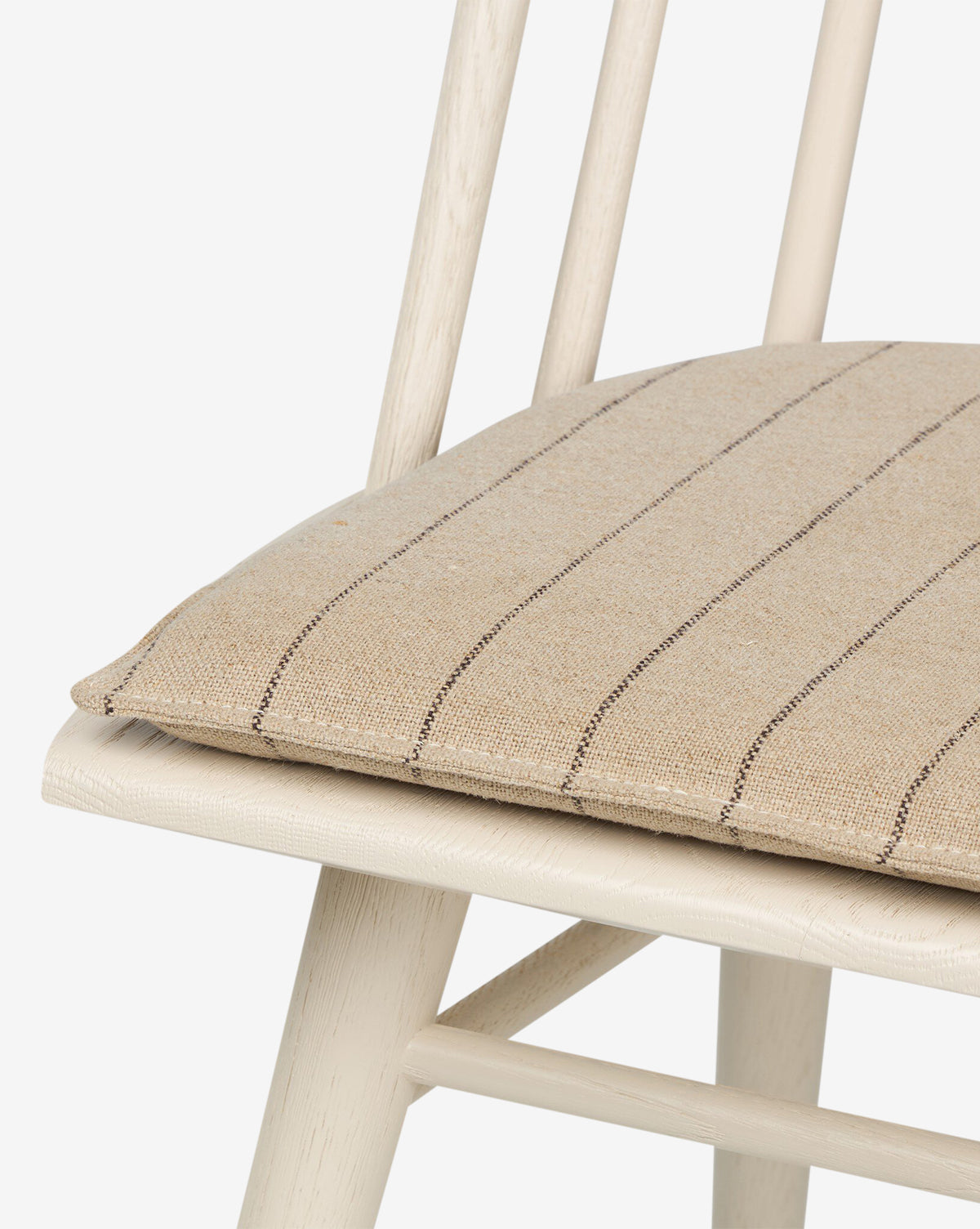 Close-up of the Madison Dining Chair featuring a beige striped seat cushion, light wood frame, and vertical back slats, shown against a plain white background, by McGee & Co.