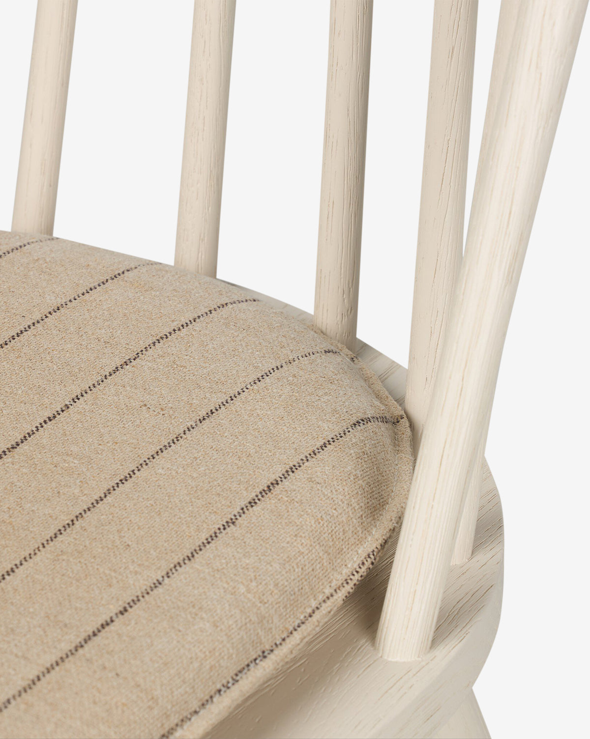 Close-up of the Madison Dining Chair, featuring light wood, vertical back slats, and a beige cushioned seat with thin dark brown stripes, by McGee & Co.