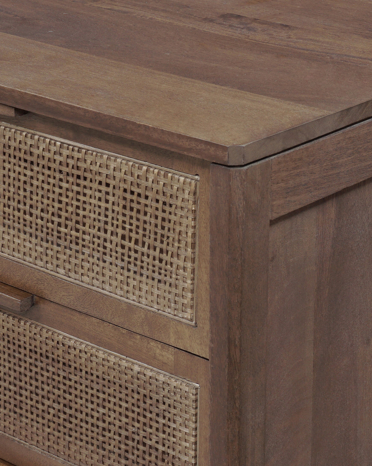 A close-up of the Margaery Nightstand’s corner shows two drawers with woven rattan panels and a smooth mango wood surface, by McGee & Co.