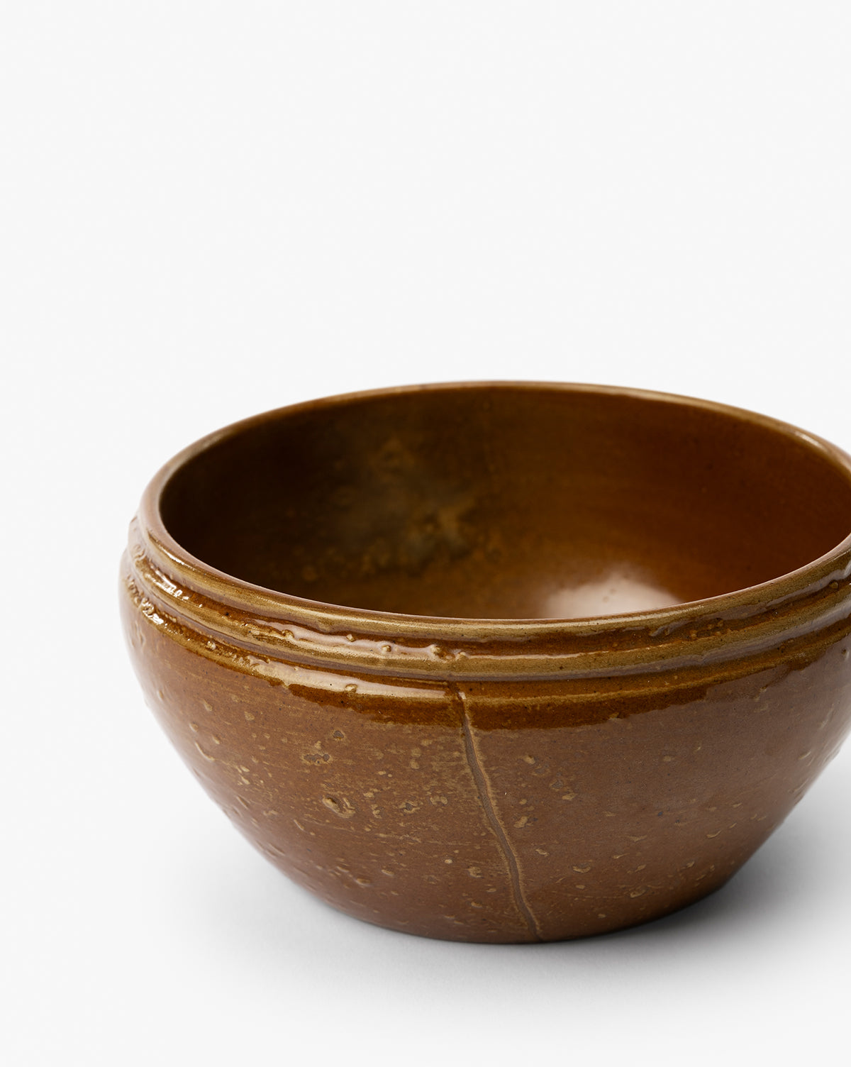 The Mariella Stoneware Bowls (Set of 4) feature round, brown stoneware with a handmade feel, glossy finish, subtle speckled texture, and two raised bands near the rim, displayed on a plain white background by McGee & Co.