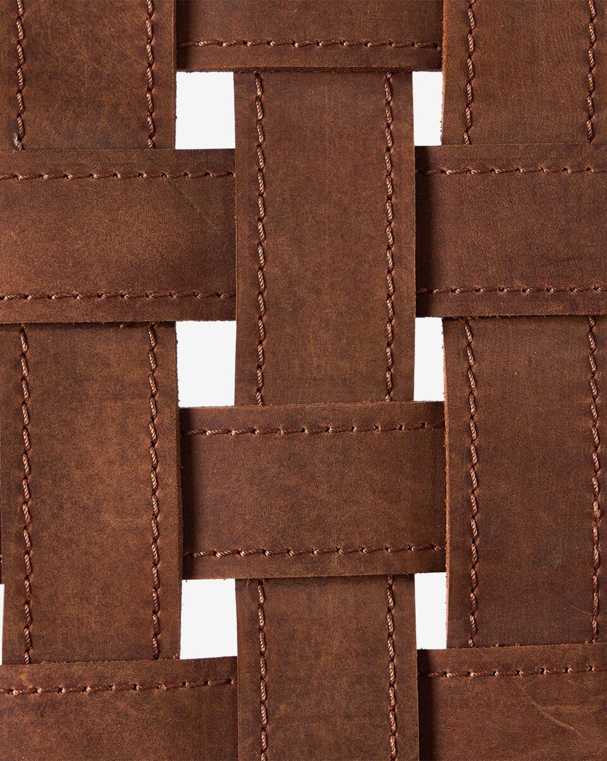 The Maris Lounge Chair features woven brown top-grain leather strips in a crisscross pattern, with stitched edges and open gaps that reveal a white background for a vintage-inspired, textured look by McGee & Co.