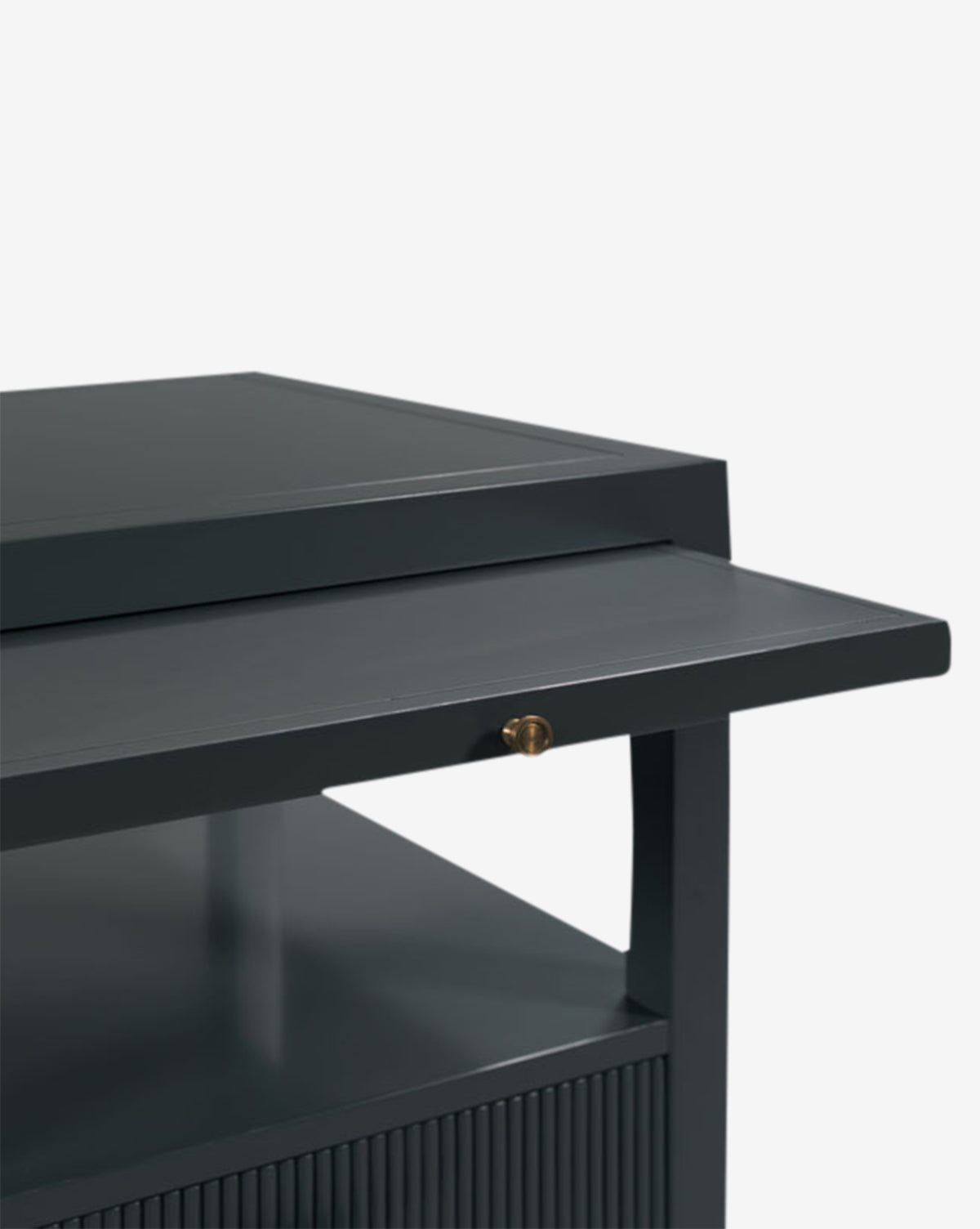 A close-up of the Martinez Nightstand reveals a dark gray cabinet with brass hardware, a pull-out tray, open shelf, and reeded drawer front featuring ribbed detailing on the lower section, by McGee & Co.