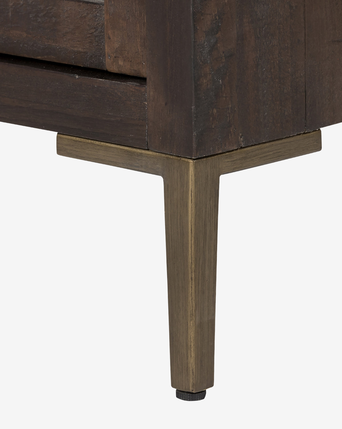 Close-up of the Maverick Cabinet’s corner, crafted from reclaimed pine with a dark finish, iron hardware, and a metal leg in brushed brass or bronze tone, set against a plain white background by McGee & Co.