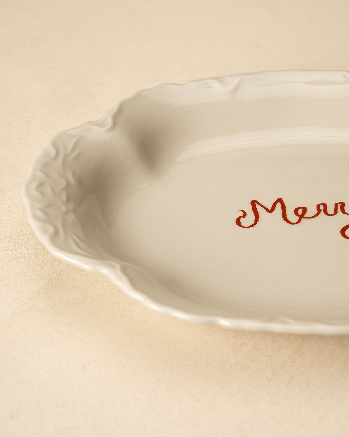 Resting on a light beige surface, this festive white serving platter is perfect for holiday table decor, by McGee & Co.