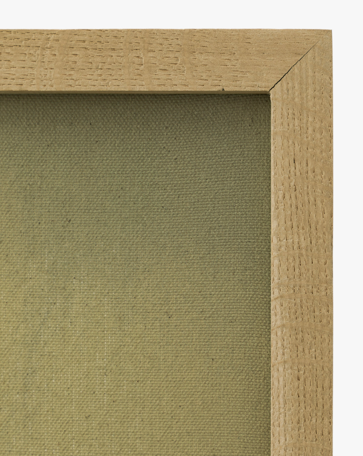 Close-up of the top right corner of a white oak frame with visible wood grain, surrounding Misty Blue Headland on a plain, textured beige canvas by McGee & Co.