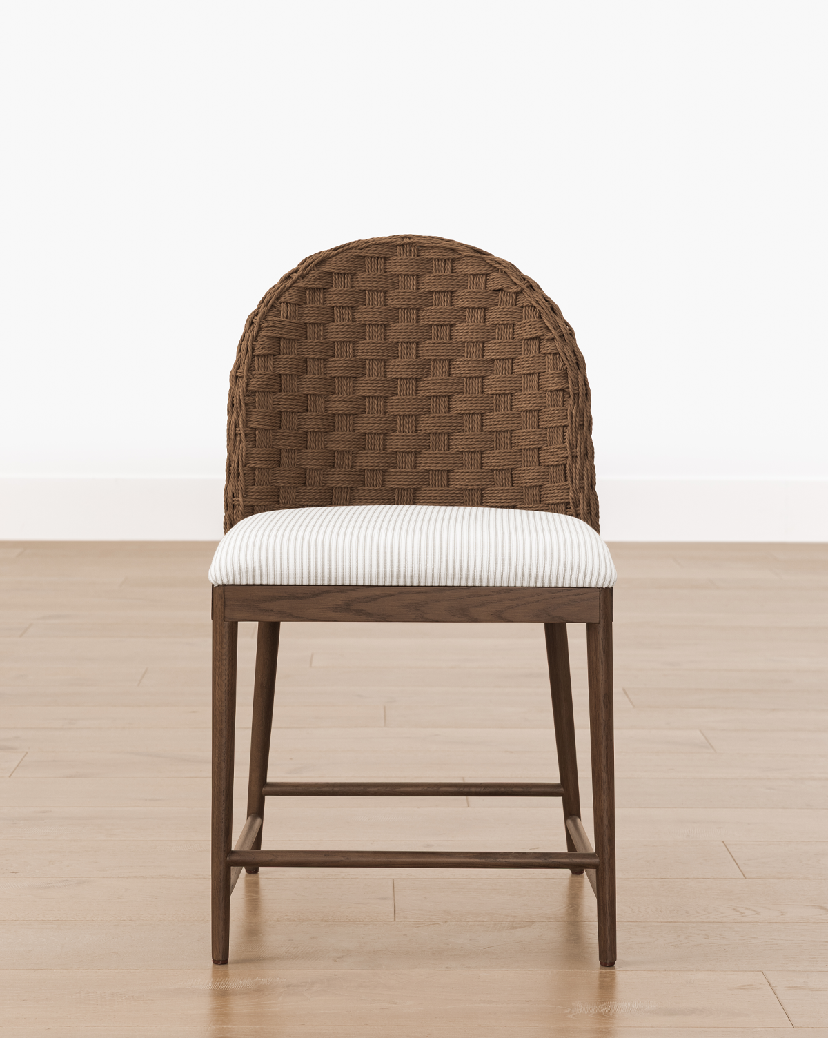 The Molly Dining Chair features a curved woven backrest and cushioned seat with white fabric and gray stripes, perfect for modern dining spaces, by McGee & Co.