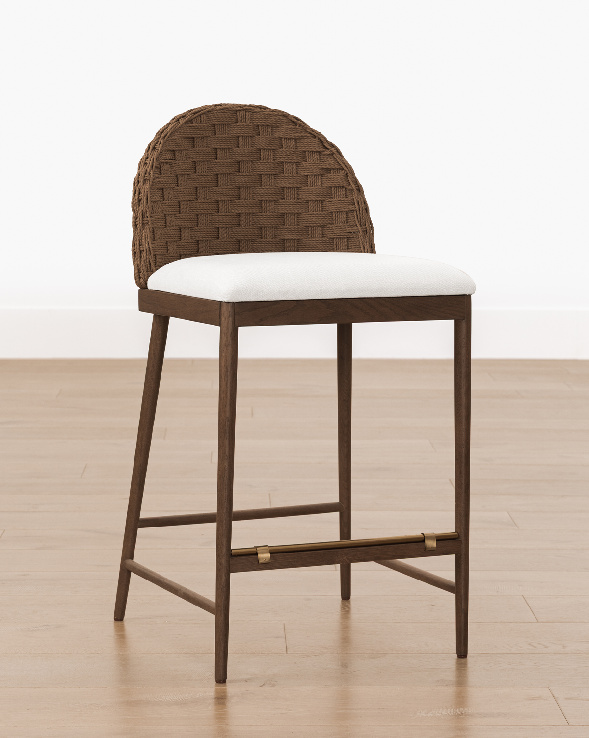 Set on a light wood floor against a plain white background, it perfectly blends style and comfort as the ideal counter stool, by McGee & Co.