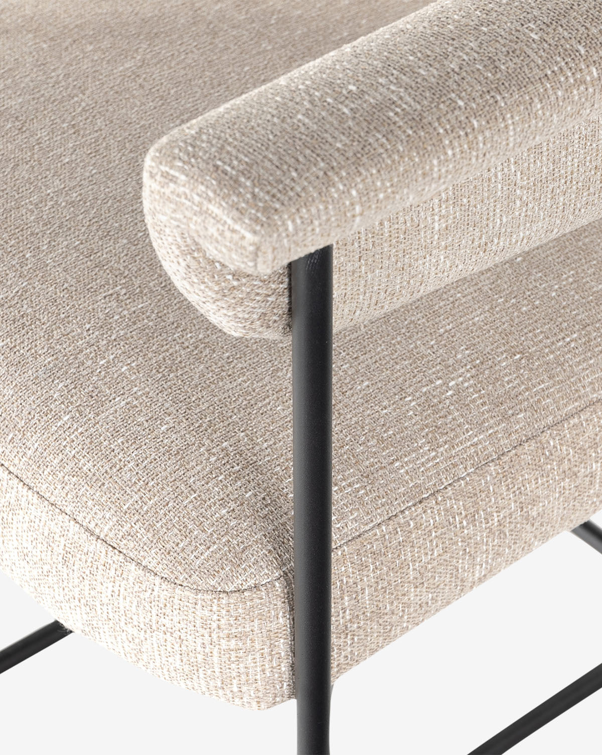 Close-up of the Monson Stool, highlighting its light beige textured fabric upholstery and sleek black metal frame, with a focus on the armrest and seat by McGee & Co.