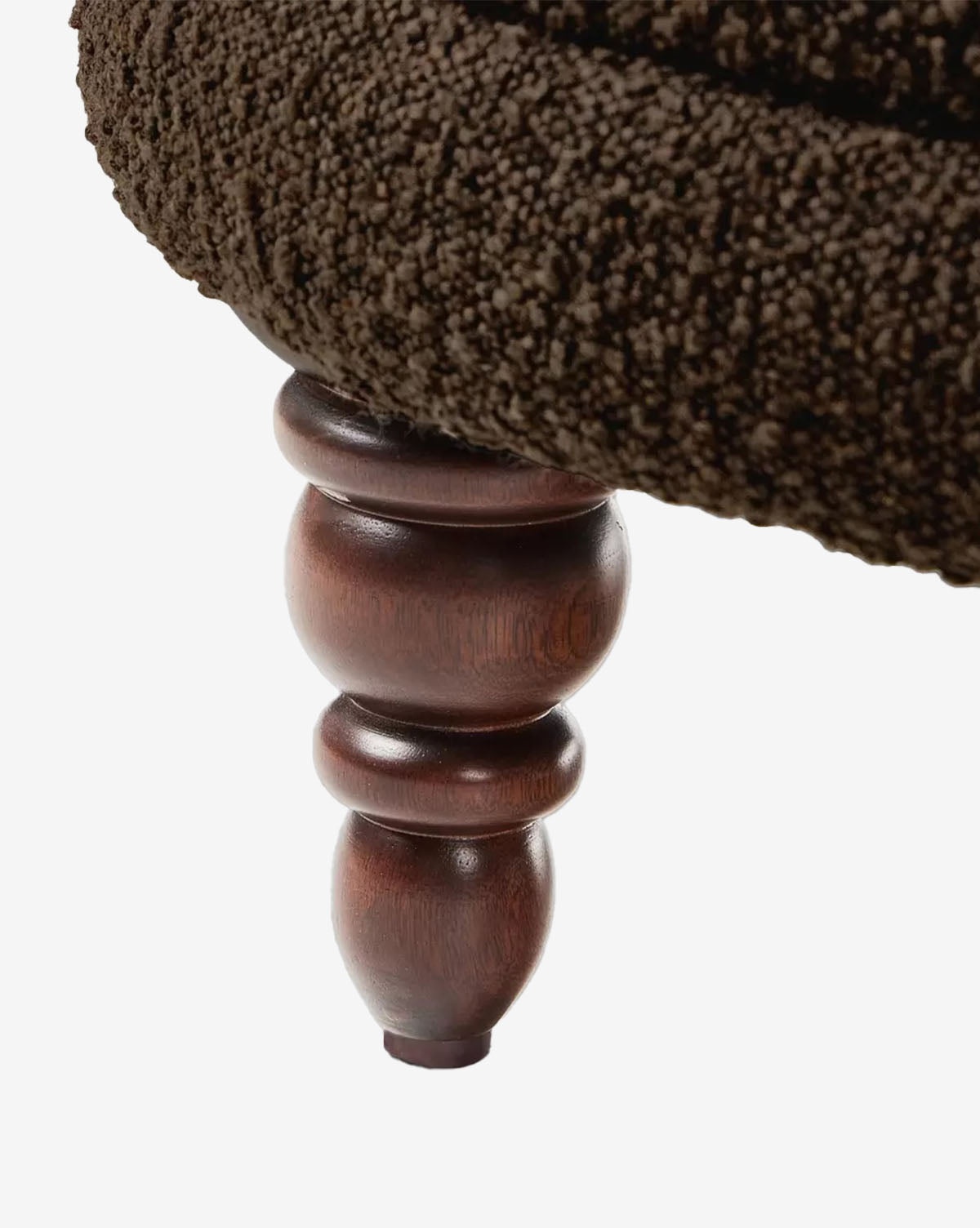 Close-up of a dark brown, textured cushion on the polished wooden leg of the Olivette Slipper Chair, highlighting its elegant fusion of traditional and modern design against a white background, by McGee & Co.