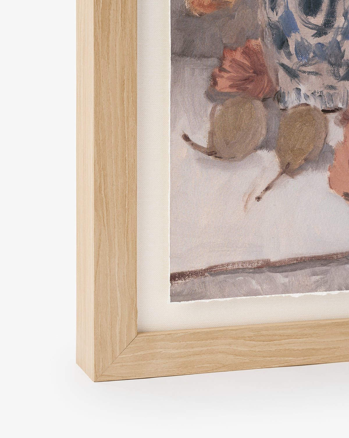 A close-up of a light wooden picture frame displays Orange Florals Still Life watercolor wall art—autumn leaves, two pears, and a blue-patterned vase on a light background, by McGee & Co.