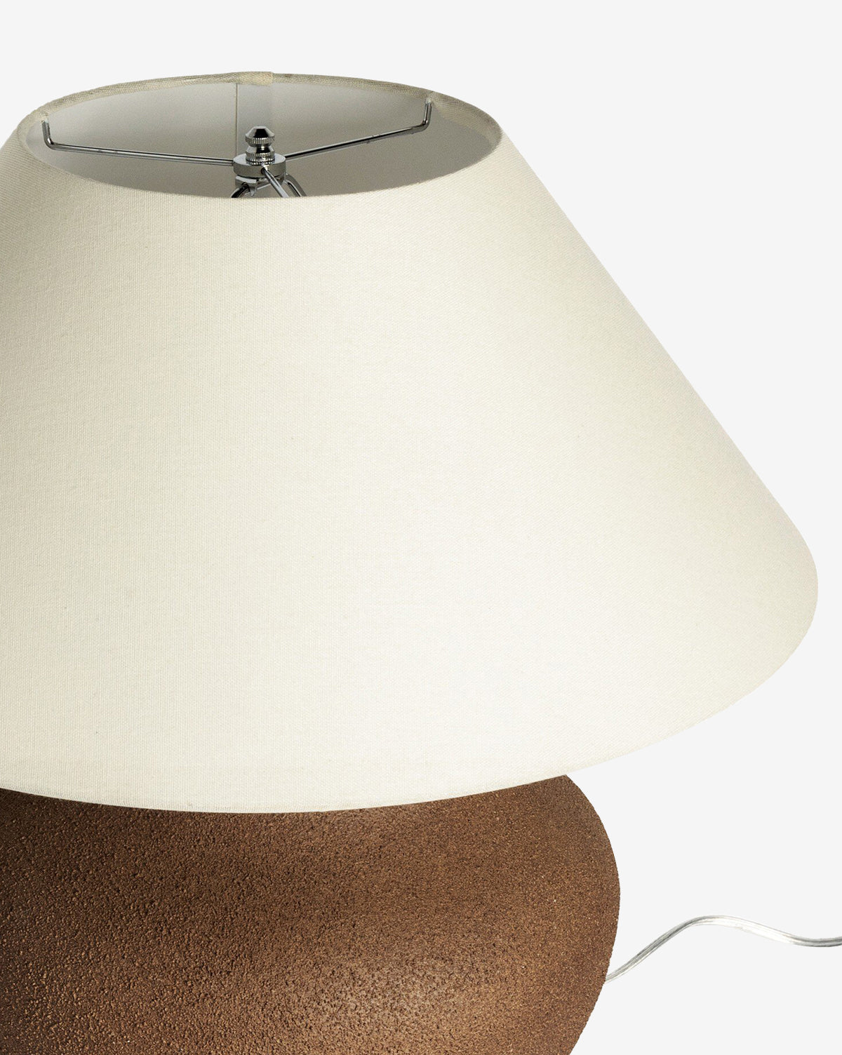 A close-up of the Parma Table Lamp shows its brown textured ceramic base and wide ivory linen shade. The lamp is set against a white background, with its metal harp and power cord partly visible, by McGee & Co.
